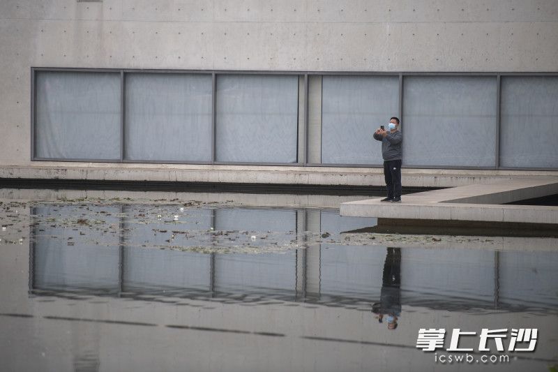 在谢子龙影像艺术馆前，游客戴着口罩在游览。全媒体记者 黄启晴 摄