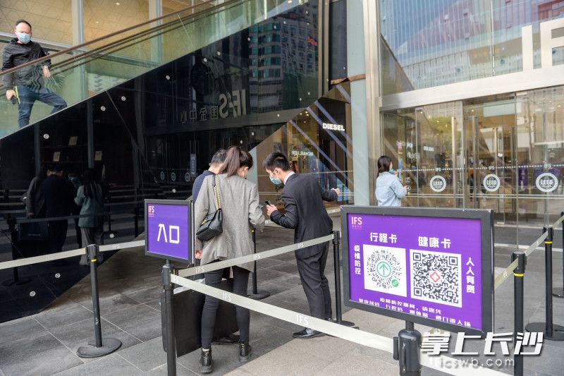 在长沙IFS国金中心出入口，市民经过查验双码、测体温、戴口罩方可进入商场。 照片均为 长沙晚报全媒体记者 陈飞 摄