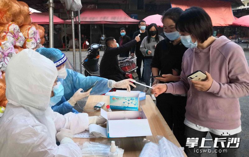 商户们排队接受检测。