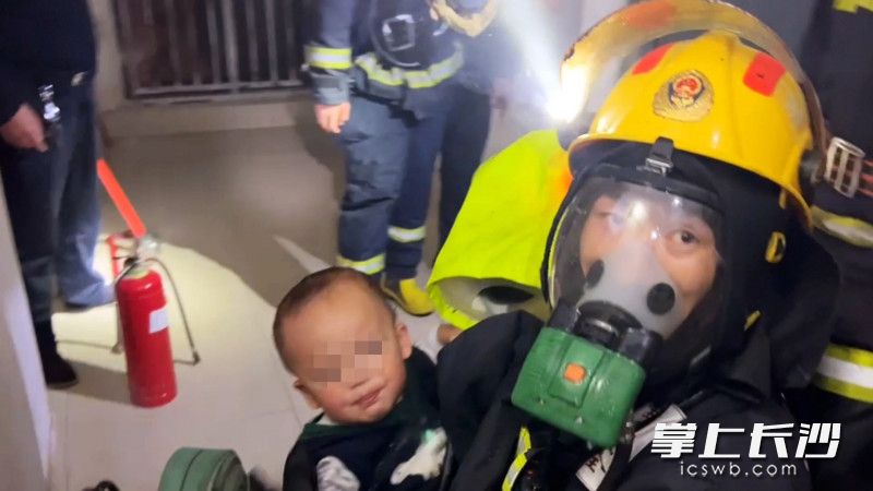 火场中，消防员将一名幼儿顺利救出。视频截图