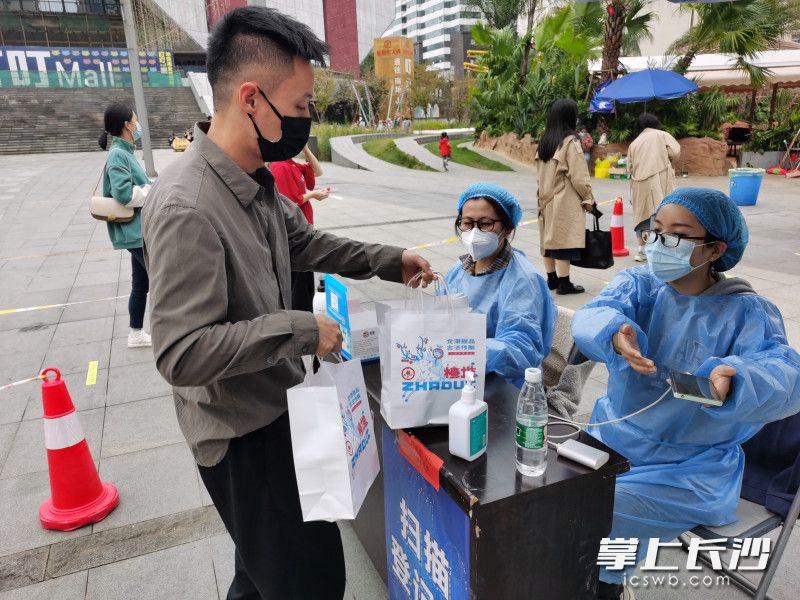 在叮叮mall广场前坪，热心市民给核酸检测工作人员送热饮料。