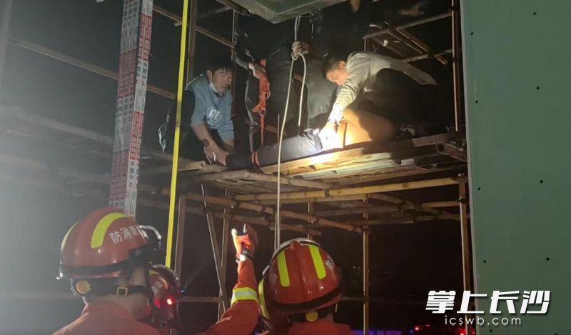 现场，消防员与工地工人合力将醉酒男子转移至安全地带。长沙晚报通讯员 刘姿 供图