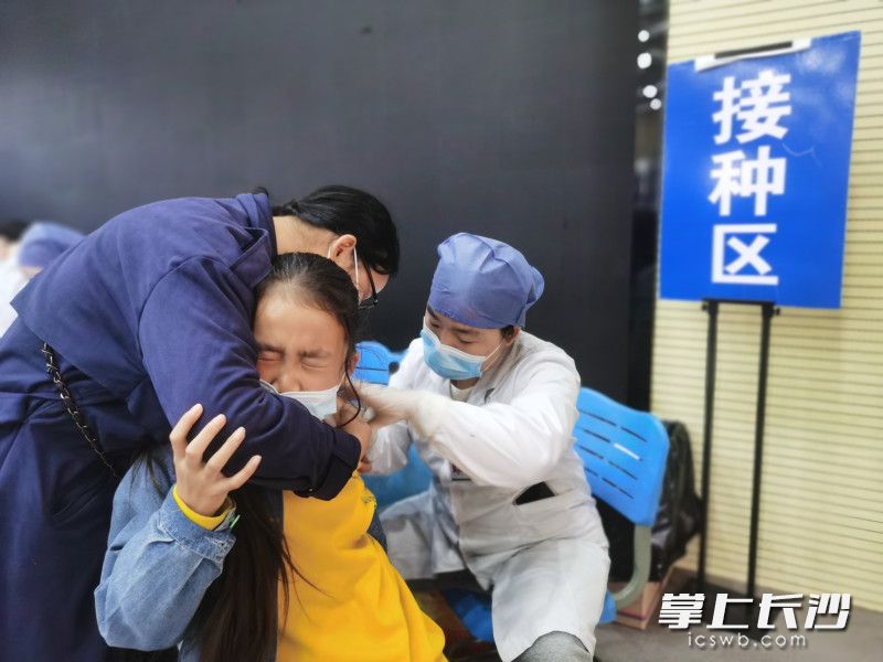 一名孩子在家人的陪同下勇敢接种疫苗。