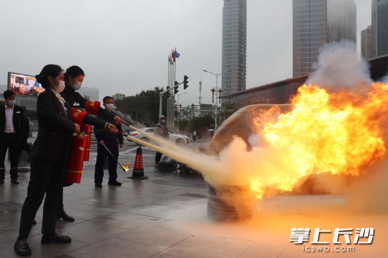 写字楼员工学习使用干粉灭火器。长沙晚报实习生 程韫玉 摄