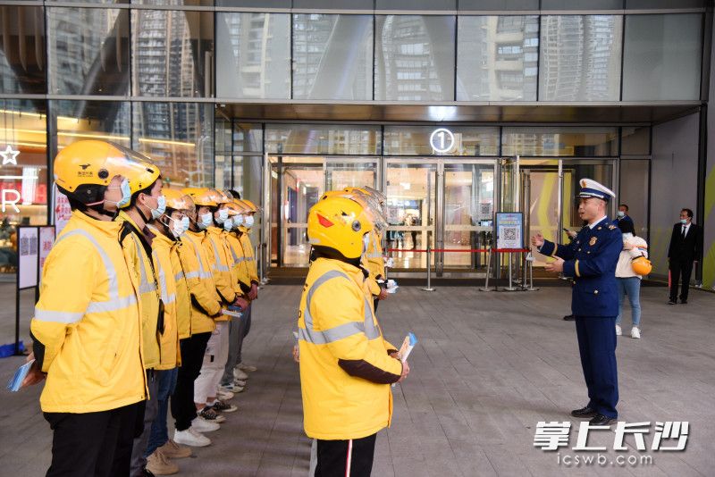 美团外卖小哥领取消防宣传折页，向群众发放，并上消防安全课。长沙晚报全媒体记者 刘琦 摄
