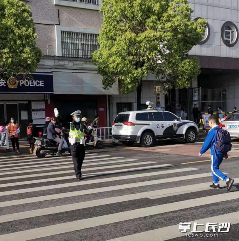 李德明在砂子塘小学门口值守护学岗。