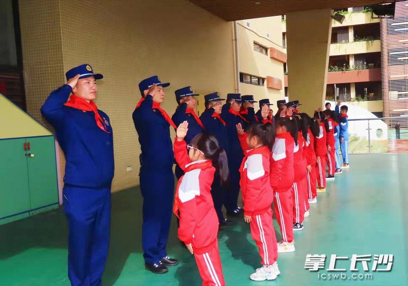 小学生与消防员互相敬礼。