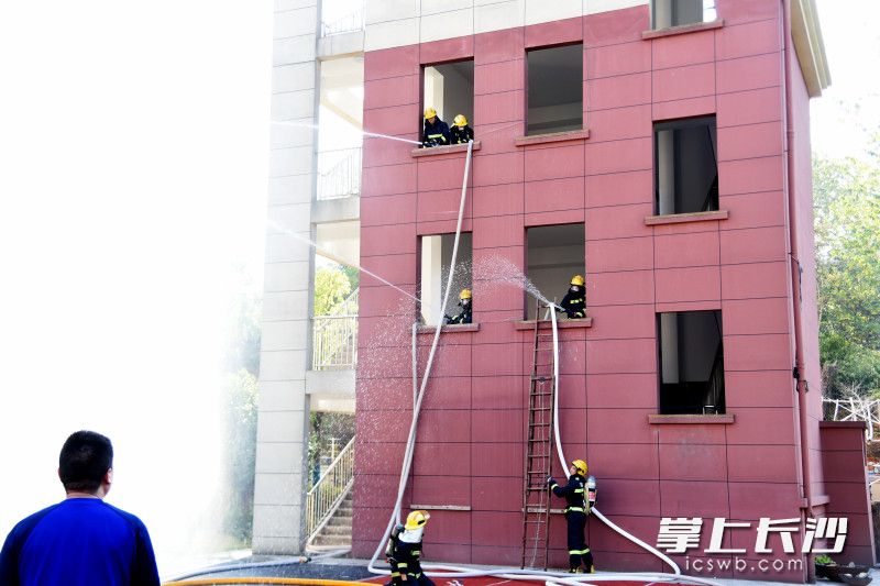 消防员为小记者展示楼层内攻灭火操。