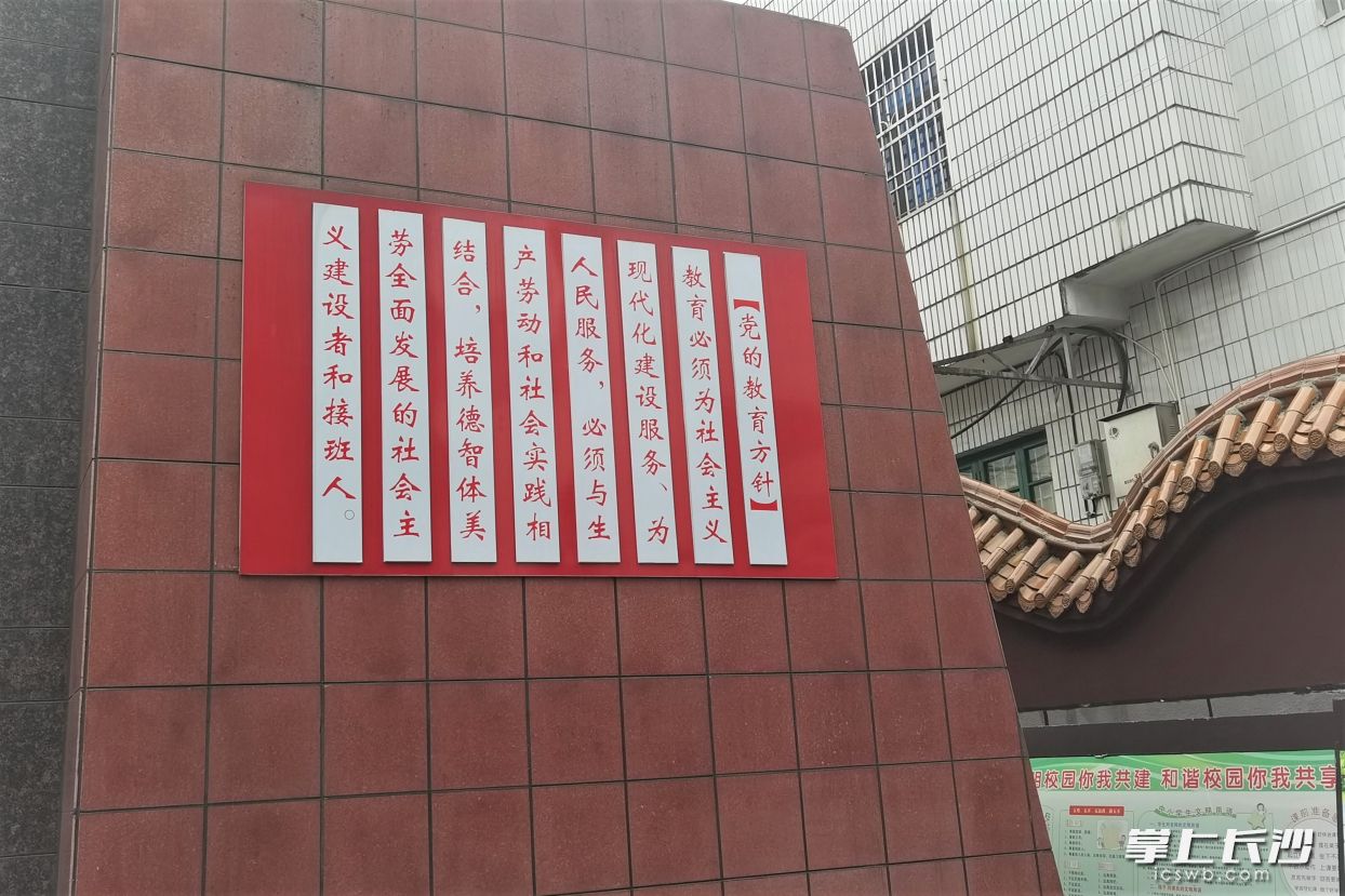 在玉潭街道紫金中学，党的教育方针铭刻在校门口。