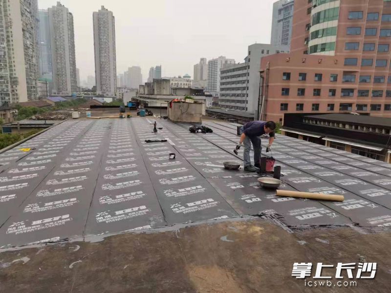 工作人员正在对漏水屋顶进行翻修。
