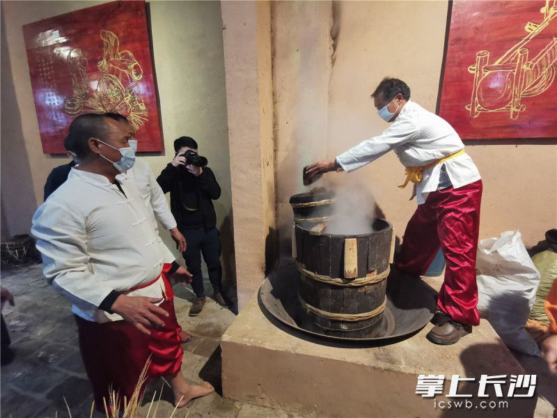 在当地古法榨油作坊，匠人们正在踩茶饼。