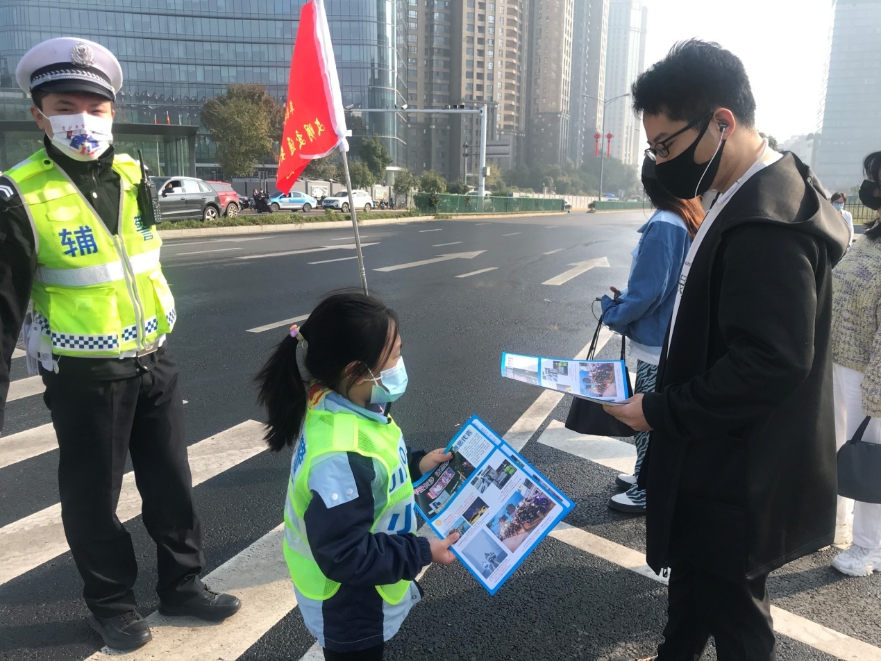 小志愿者向市民发放文明交通宣传资料。