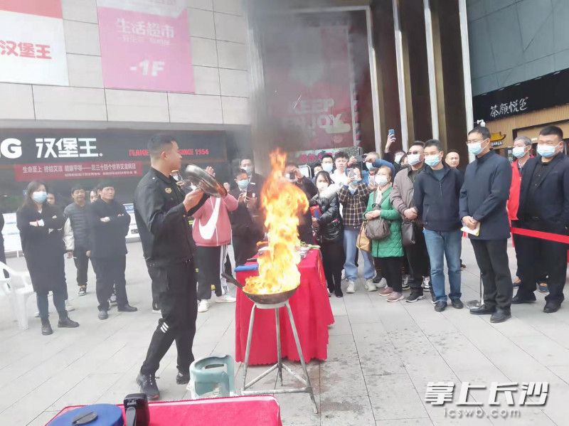 消防员展示如何用锅盖灭火。
