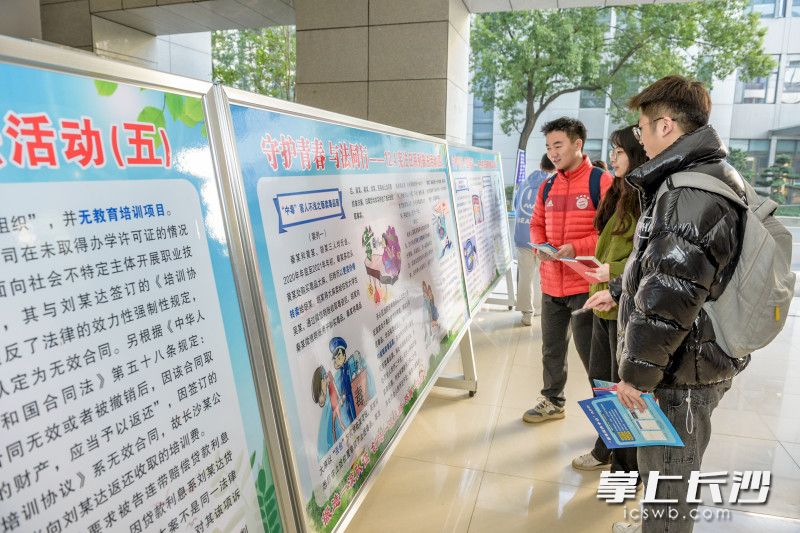 大学生们在阅读展板。