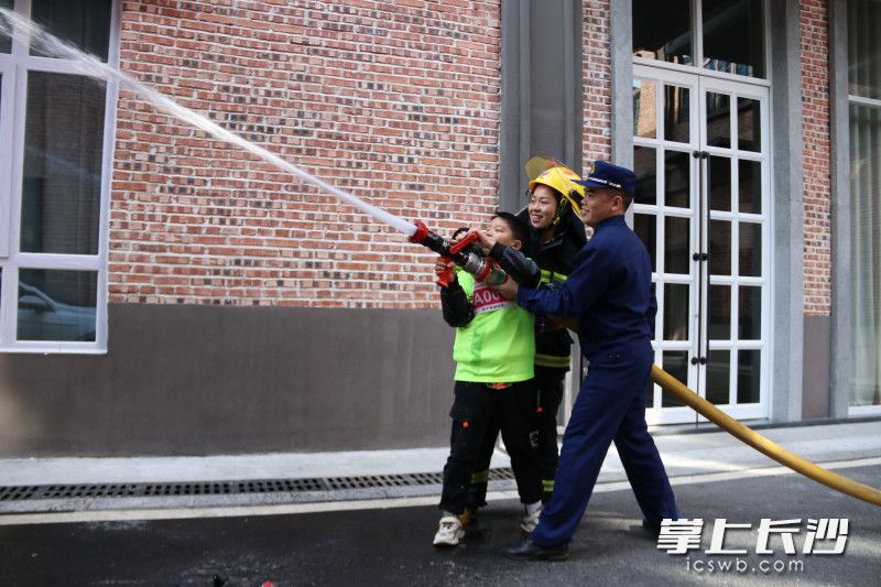 活动现场，追风少年、家长共同体验消防员的灭火救援“日常”。均为长沙晚报通讯员 冯运文 供图