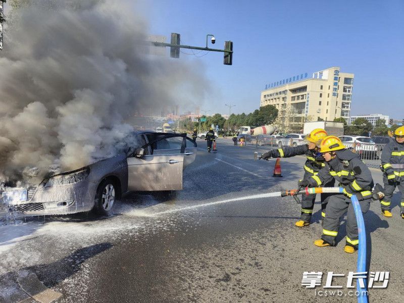现场，消防员出水枪对自燃车辆进行灭火。经开消防 供图