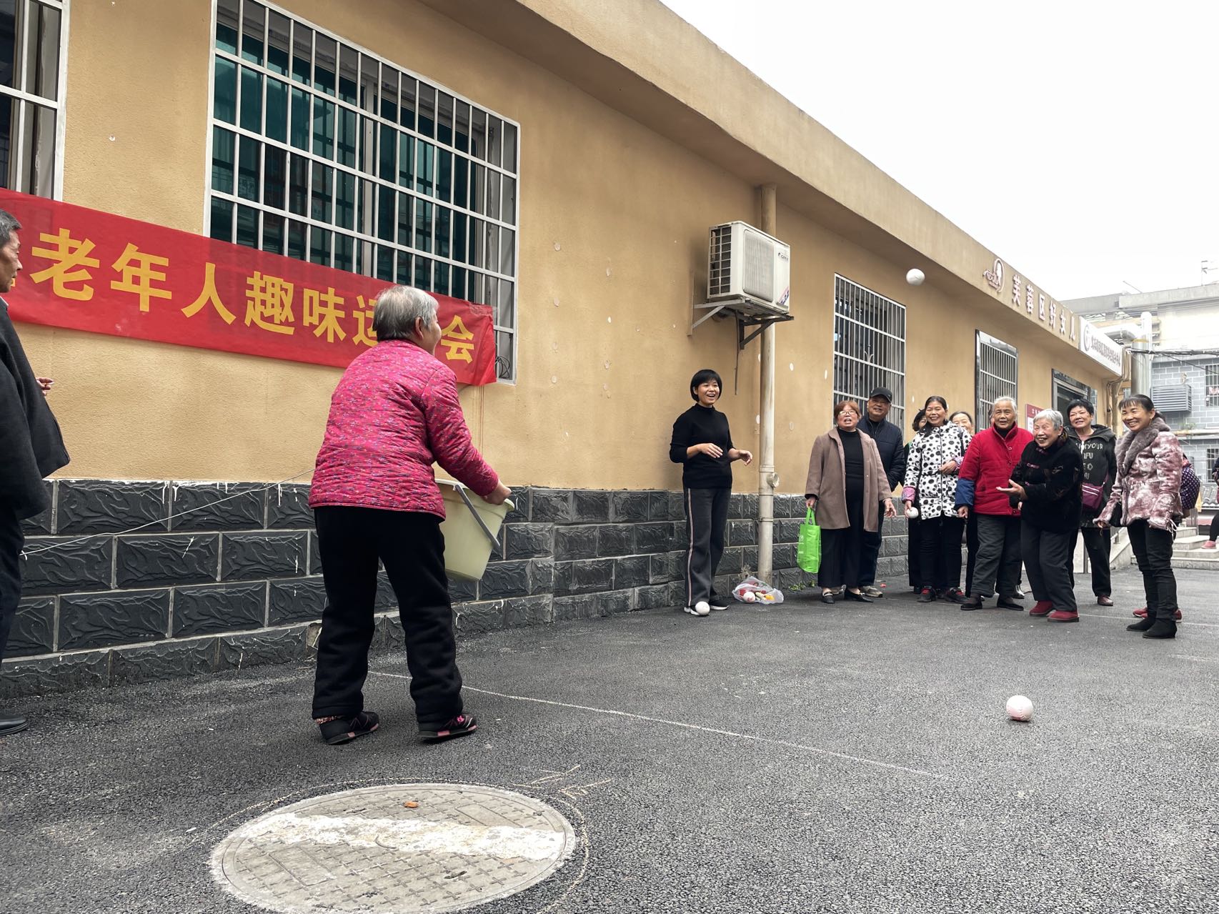 老人正在参加趣味投篮比赛。