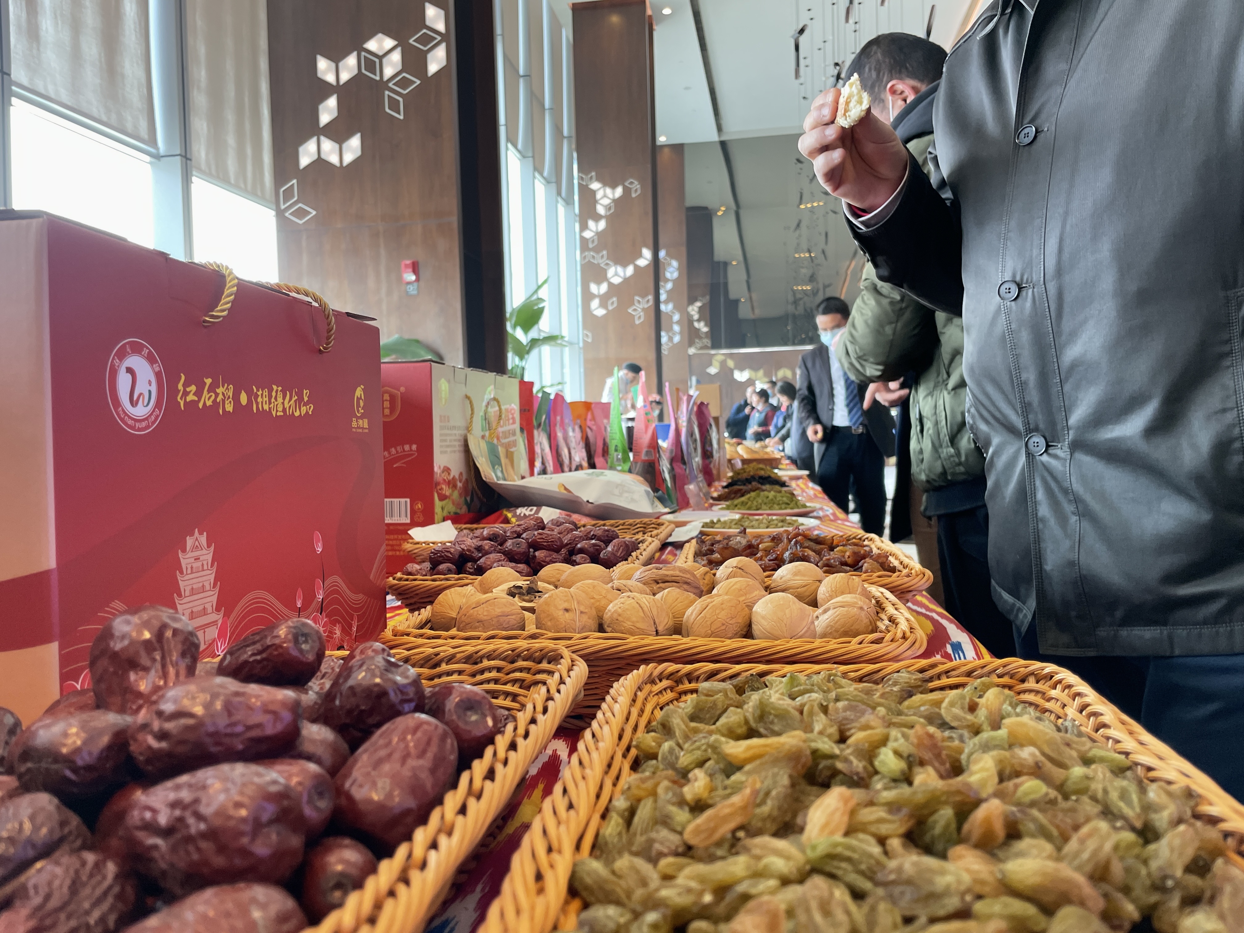 推介会的会场旁，大家品尝来自新疆的农副产品。 长沙晚报全媒体记者 聂映荣 摄