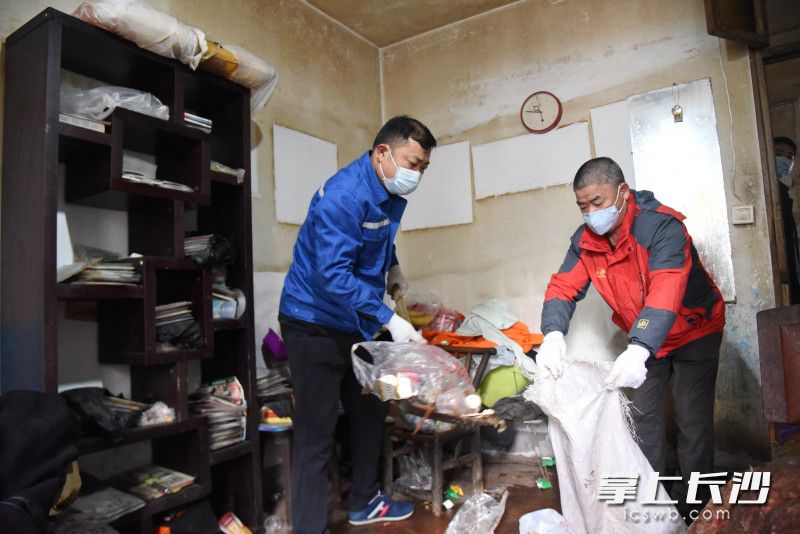 在小波家中，孙家闯（左）和志愿者一起进行大扫除，清理垃圾。均为长沙晚报全媒体记者 刘琦 摄
