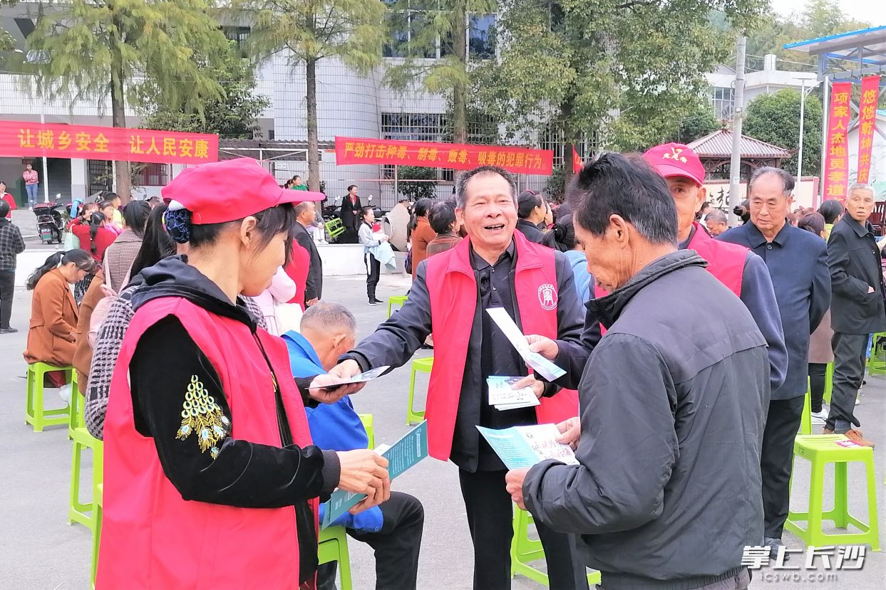 在村民文化广场上，老年志愿者给村民群众发放禁毒宣传资料。长沙晚报全媒体记者 张禹 通讯员 孙新明 邱继行 摄影报道
