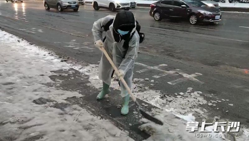 长沙2路公交车司机肖壬根为公交站台铲除冰雪。长沙晚报通讯员 王国光 摄