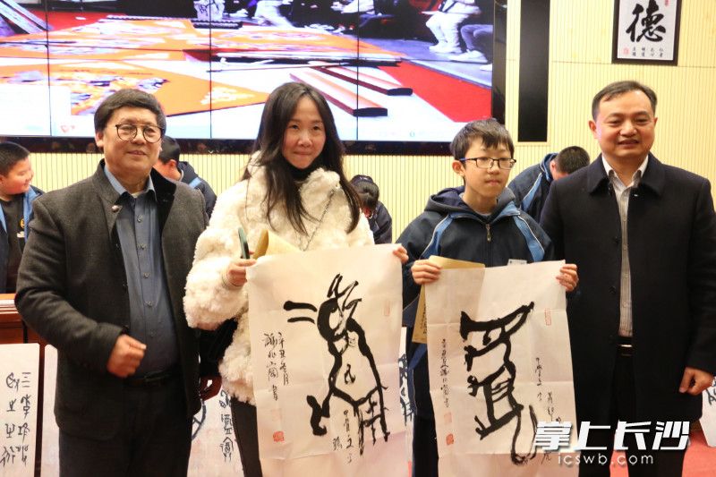 谢兆岗（左一）和长雅中学校长许庆丰（右一）为学生和家长送去了甲骨文书法作品。
