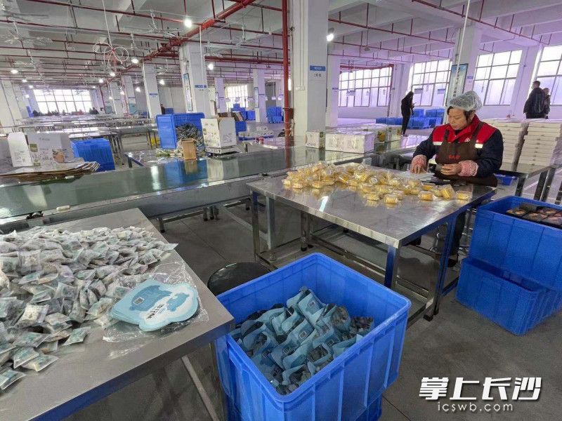 益阳市福星食品有限公司(有成斋)内，村民们正在包装糕点。