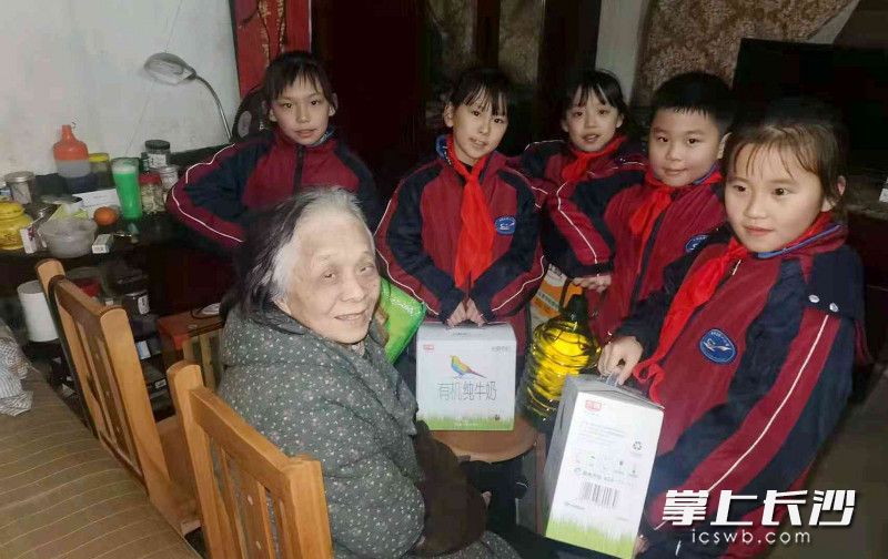 孩子们为周奶奶送上了牛奶、米油等过年礼品。通讯员 左文娟 摄