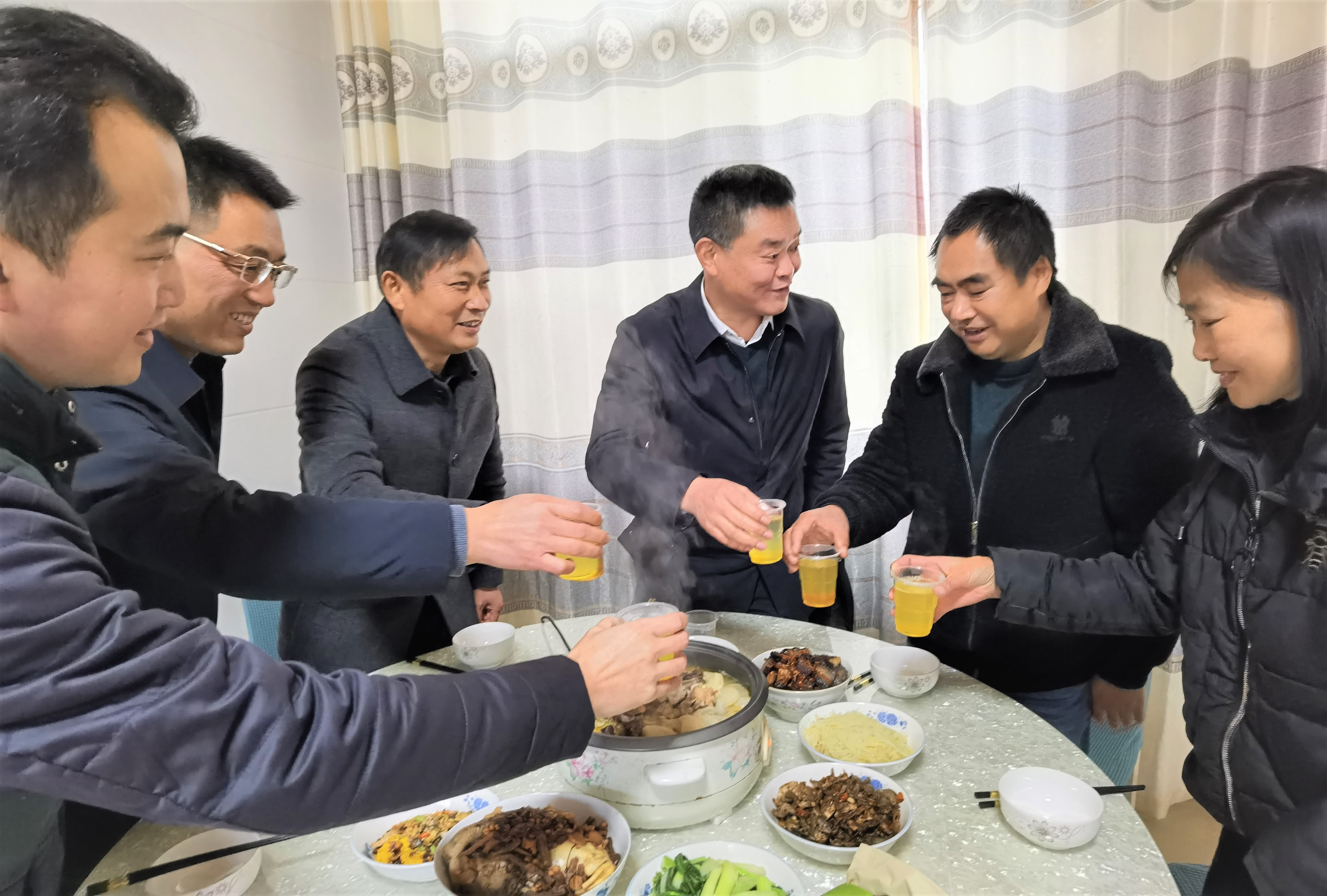 “咱们就以蜜当酒，干杯！”在宁乡市煤炭坝镇双龙村，蔡国庆（右二）为大家斟满了一杯杯蜂蜜“酒”，暖心的小年饭浓厚了党群情，贴近了干群心。长沙晚报全媒体记者 张禹 摄