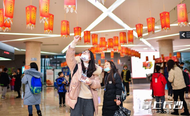 家长带着孩子正在猜灯谜。