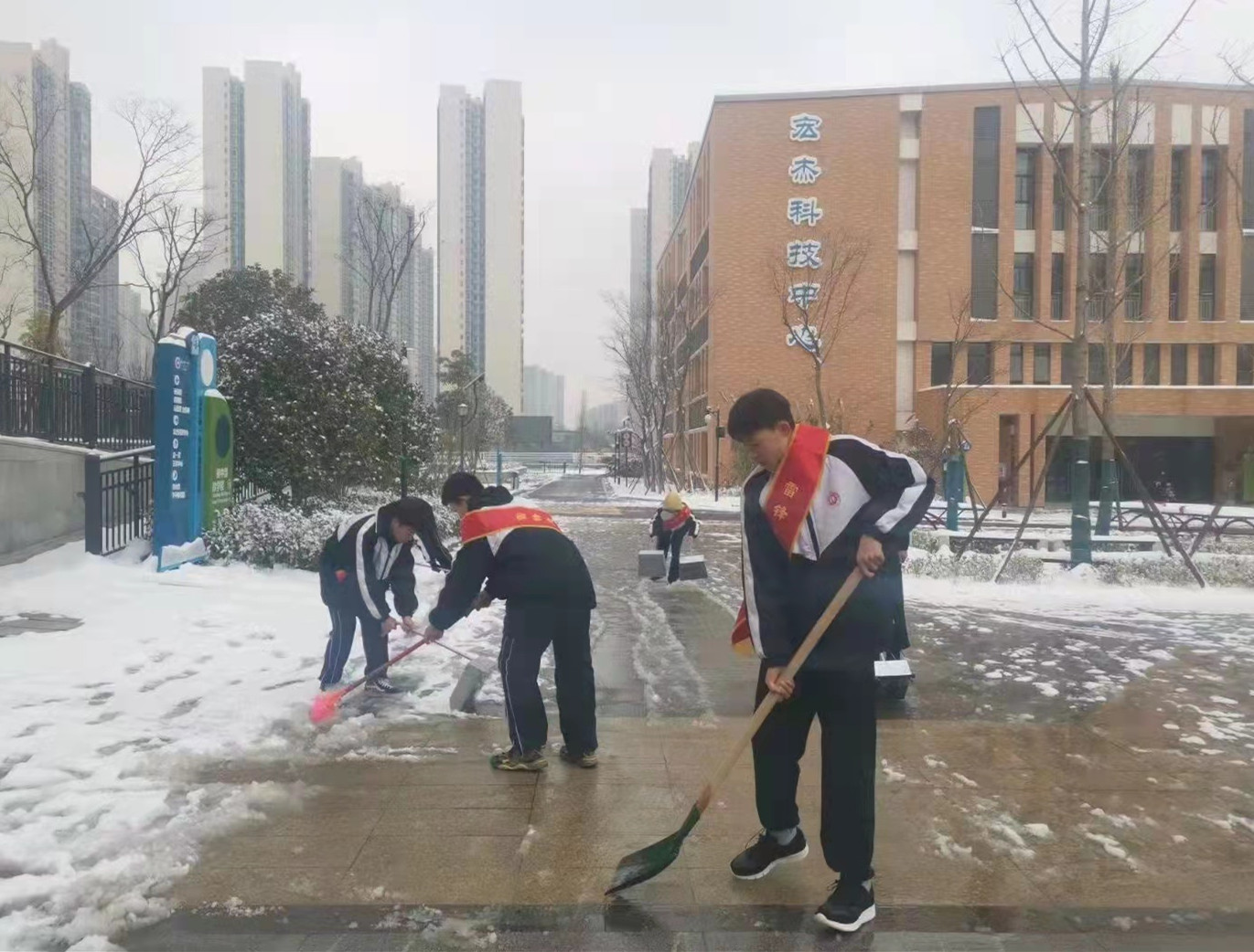 长沙市一中金山桥学校内，几名学雷锋志愿者们正在扫雪。均为长沙晚报通讯员 彭园琛 供图