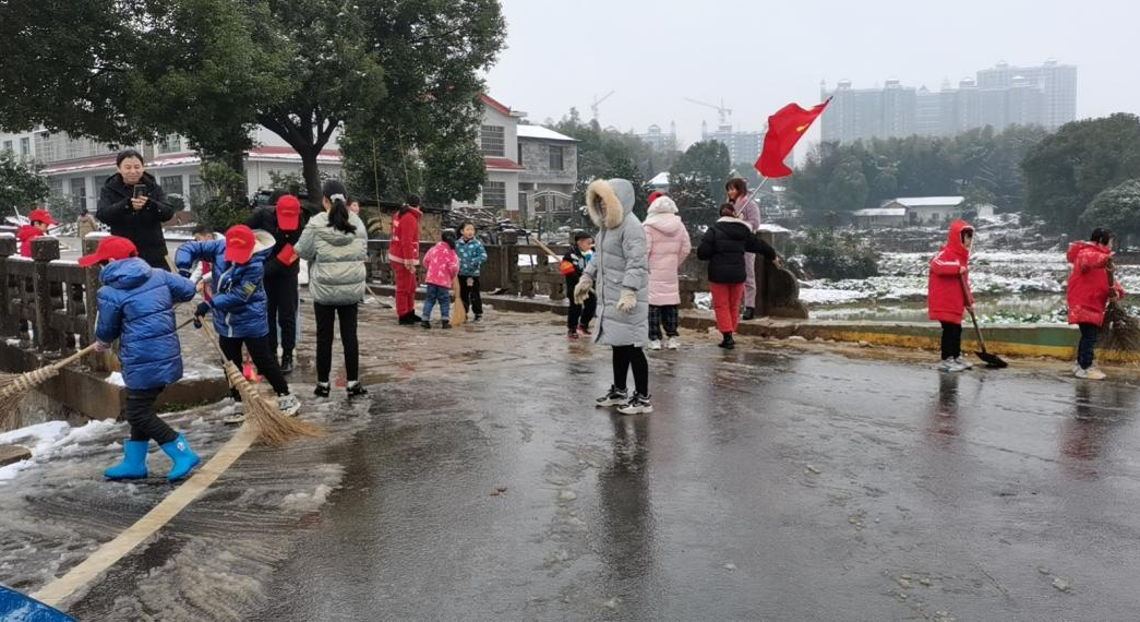在丁字湾街道，一些学生在父母带领下参与扫雪。