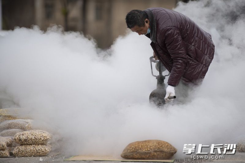 在开福寺路，一位打爆米花的手艺人喜迎了不少路人围观