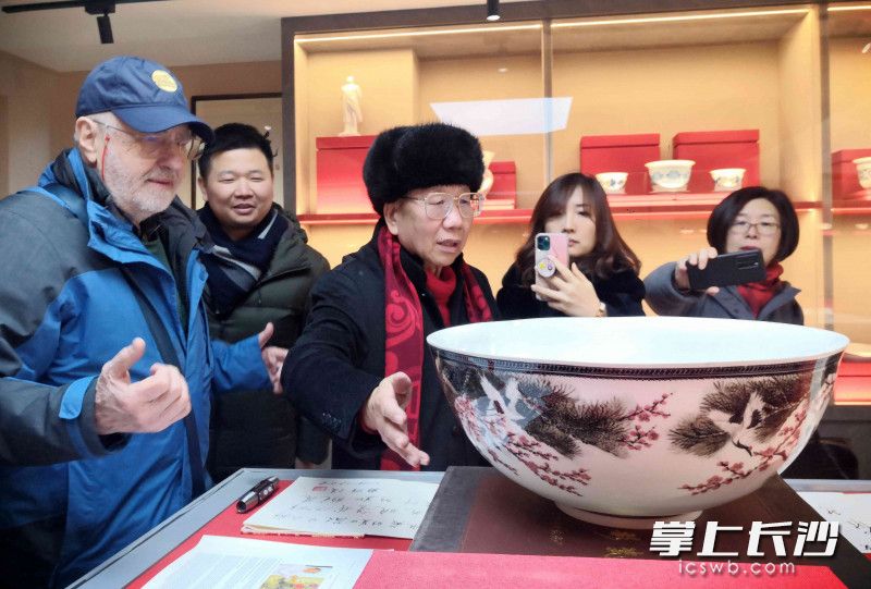 罗玉其（左三）在向参观者介绍自己的藏品。 均为长沙晚报全媒体记者 贺文兵 摄