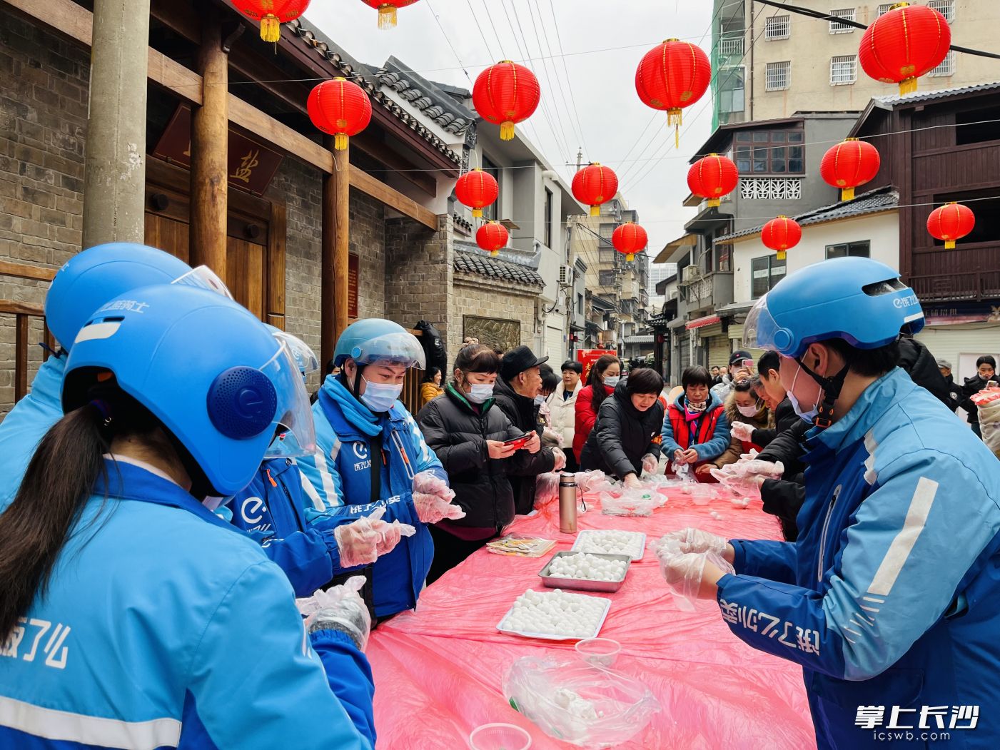 西长街工作生活了很多快递小哥、小姐姐，他们也在工作之余和街坊们一起搓汤圆同乐。