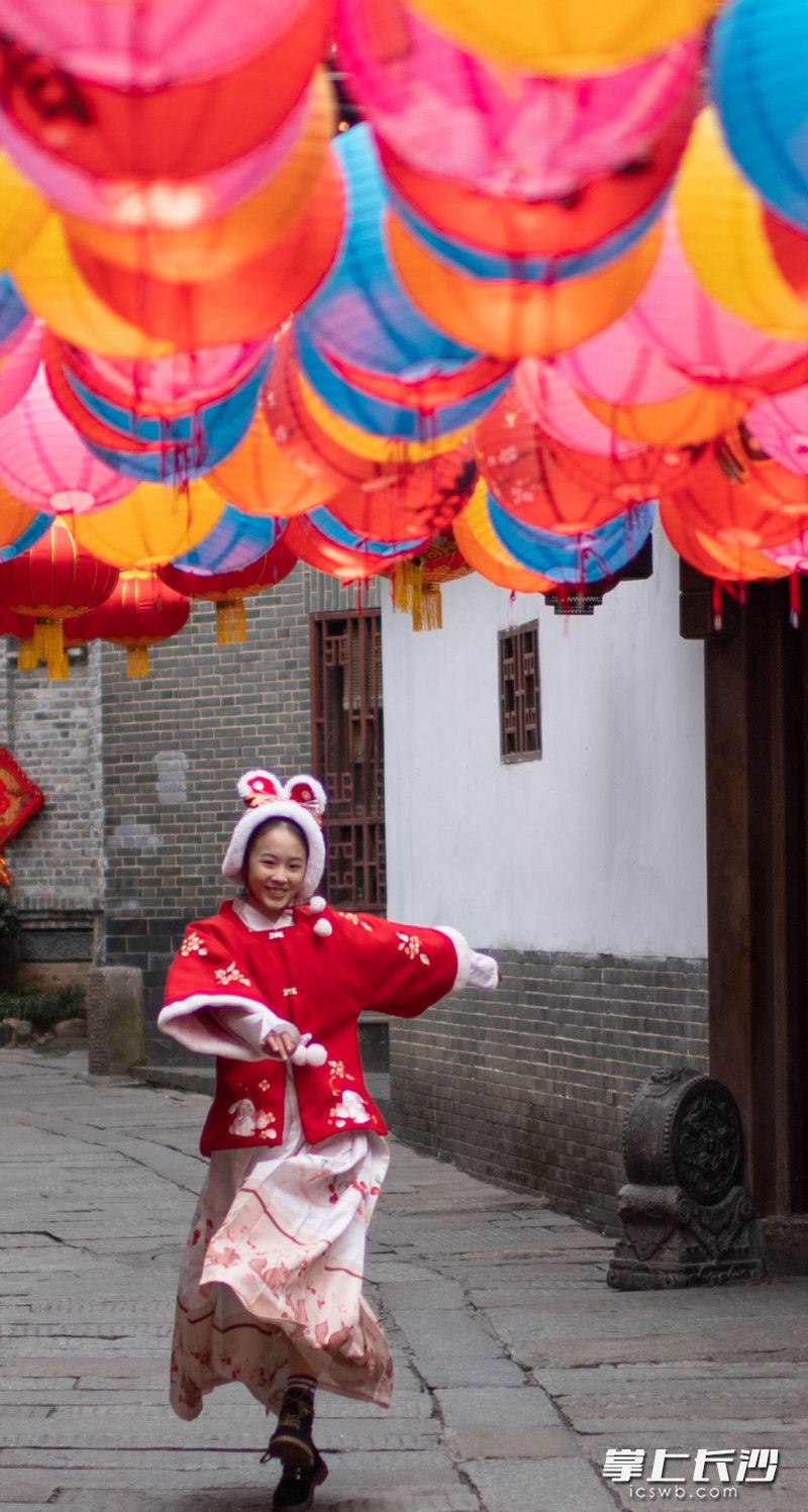 一位身穿传统服装的女孩在白果园老街上欢乐奔跑。