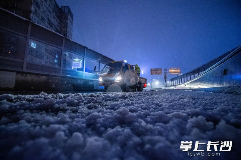 在万家丽路高架三一大道互通，来自长沙市城市桥梁隧道事务中心工作人员在给匝道铺设麻布袋，防止路面结冰打滑保障车辆行驶安全。