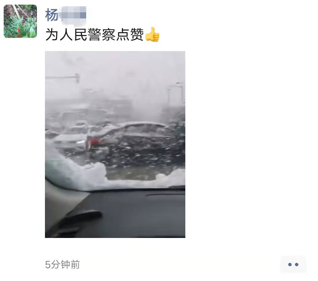 路过的群众拍下在雪中疏导交通的民警，并发朋友圈为其点赞。