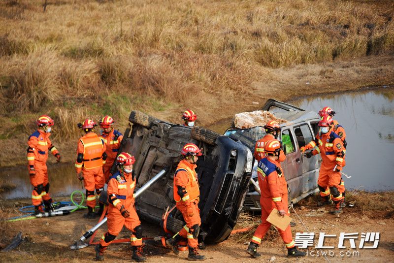 在一处水塘边，消防救援人员营救“地震”中事故车辆上的“被困人员”。