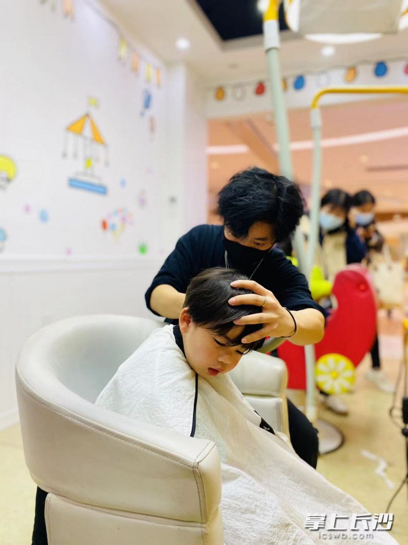理发师正为一位小朋友理发。 理发师正为一位小朋友理发。