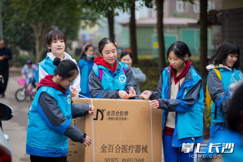 近日，湖南师范大学附属中学“蓝精灵”青年志愿者总队来到雨花区时代阳光大道的粟塘小区将粟塘小区14户残障青年家庭，将他们“愿望清单”上的物品一一交接给大家。均为学校供图