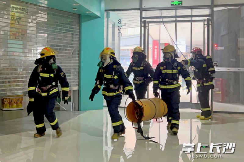 消防救援人员携带装备进入“火灾”现场。