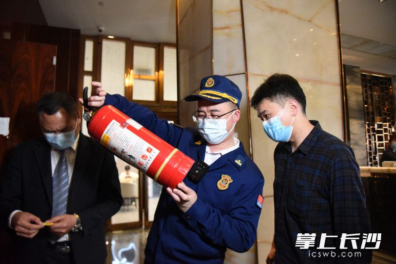在华晨豪生大酒店，消防监督员对酒店使用的灭火器进行抽样检查。均为长沙晚报全媒体记者 刘琦 摄