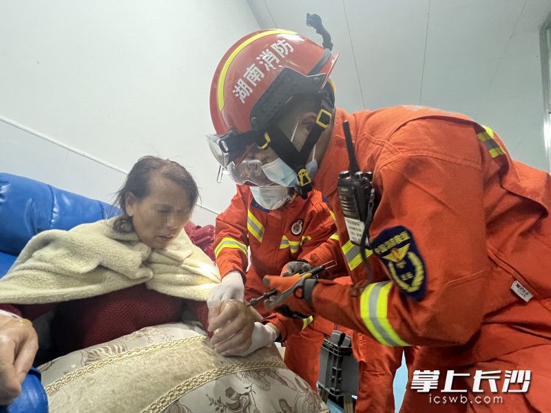 诊所内，消防救援人员合力将金手镯破拆后取下。长沙晚报通讯员 胡宇波 供图