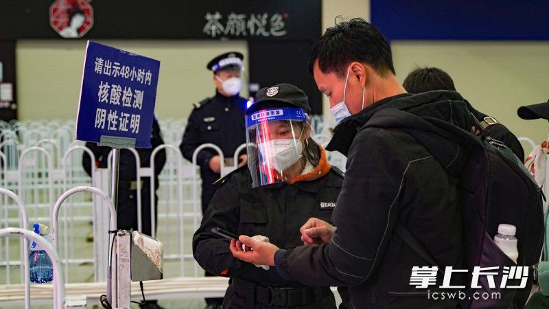 长沙火车南站保安正在检查乘客健康码和场所码。
