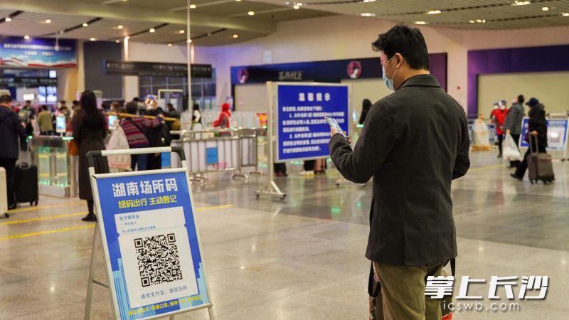 长沙火车南站内，旅客正在自觉扫描湖南场所码。