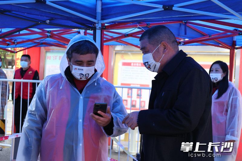 列提普·图热主动请缨，走访门店宣传疫情防控相关知识。 全媒体记者 周游 通讯员 李丹 摄