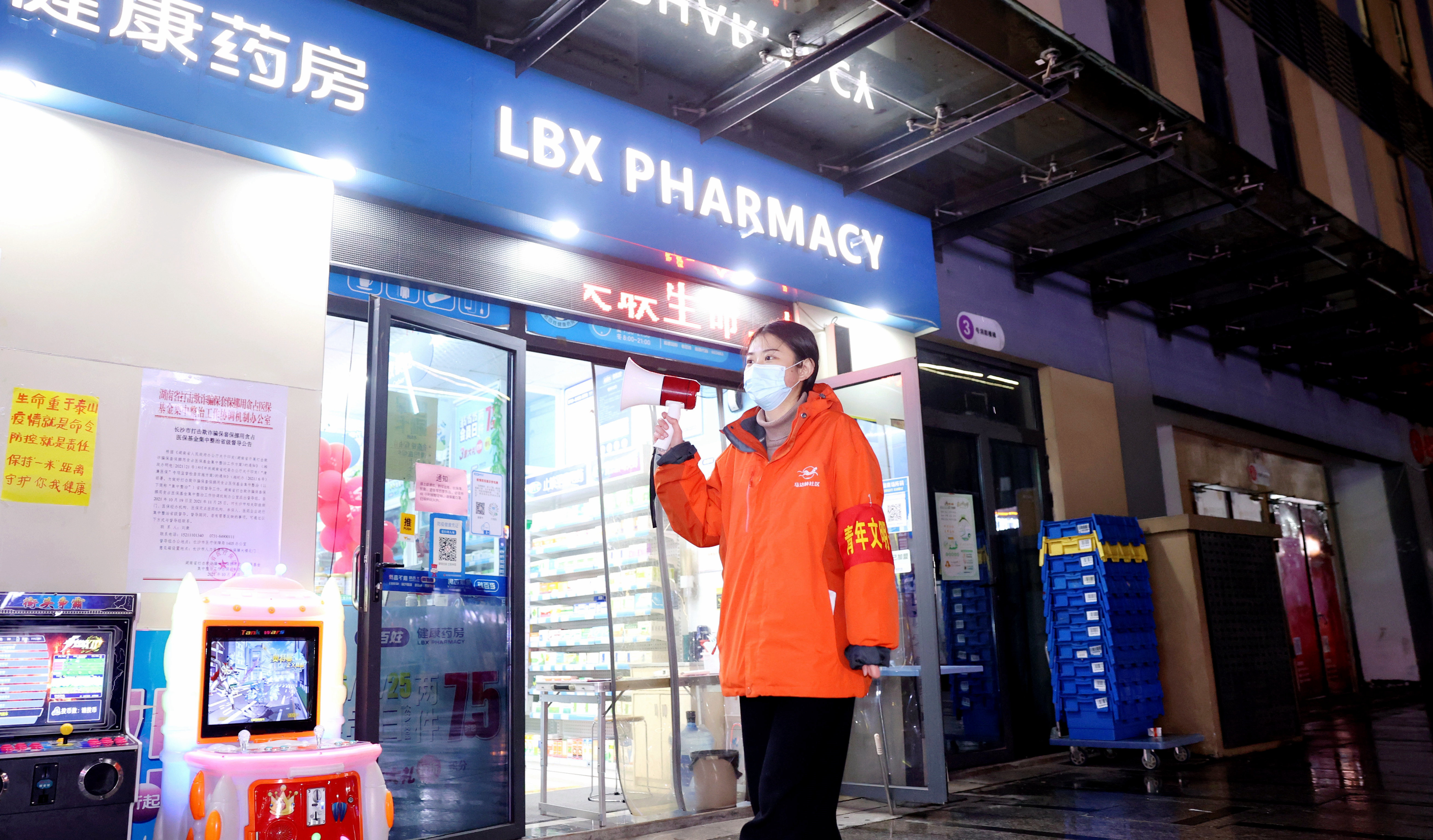 3月21日晚，马达岭社区青年志愿者张文敏通过扩音器提醒周边小区居民及时做核酸检测。长沙晚报通讯员盛磊 摄