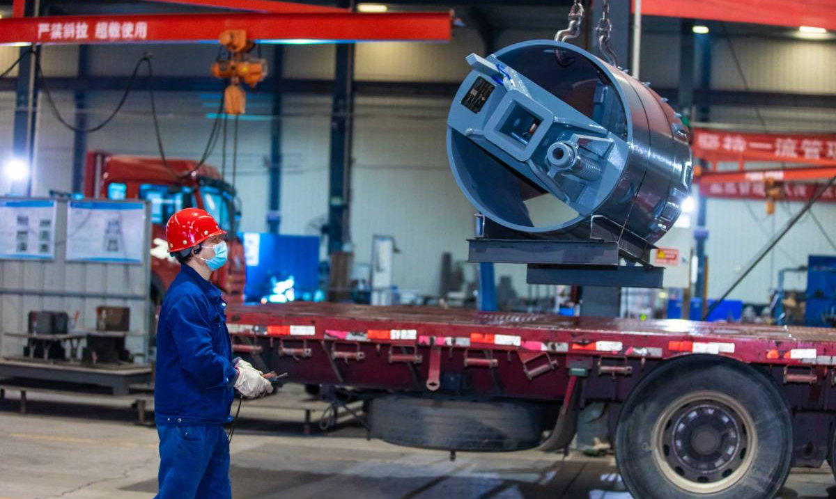 金刚机械生产车间里，产业工人正吊起一台钻具准备装车。