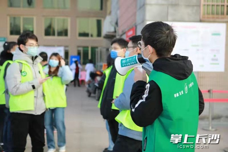 汪玮（右）正在湖南大学核酸检测点维持现场秩序。长沙晚报通讯员 尹嘉骥 摄